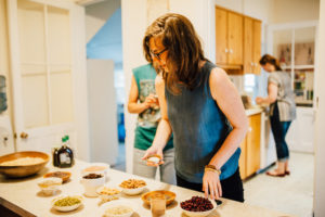 Women in kitchen preparing food with tenderness.